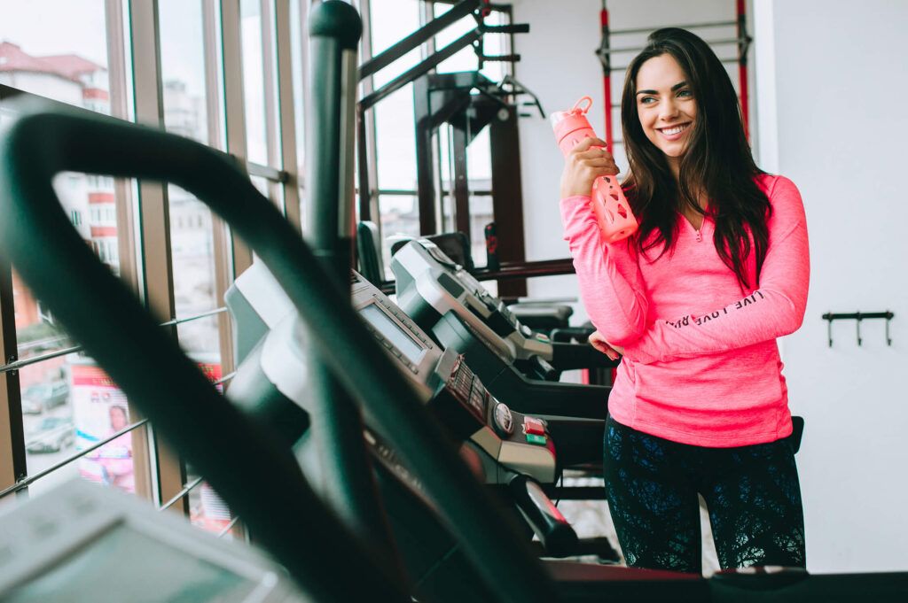 chica joven gimnasio botella agua