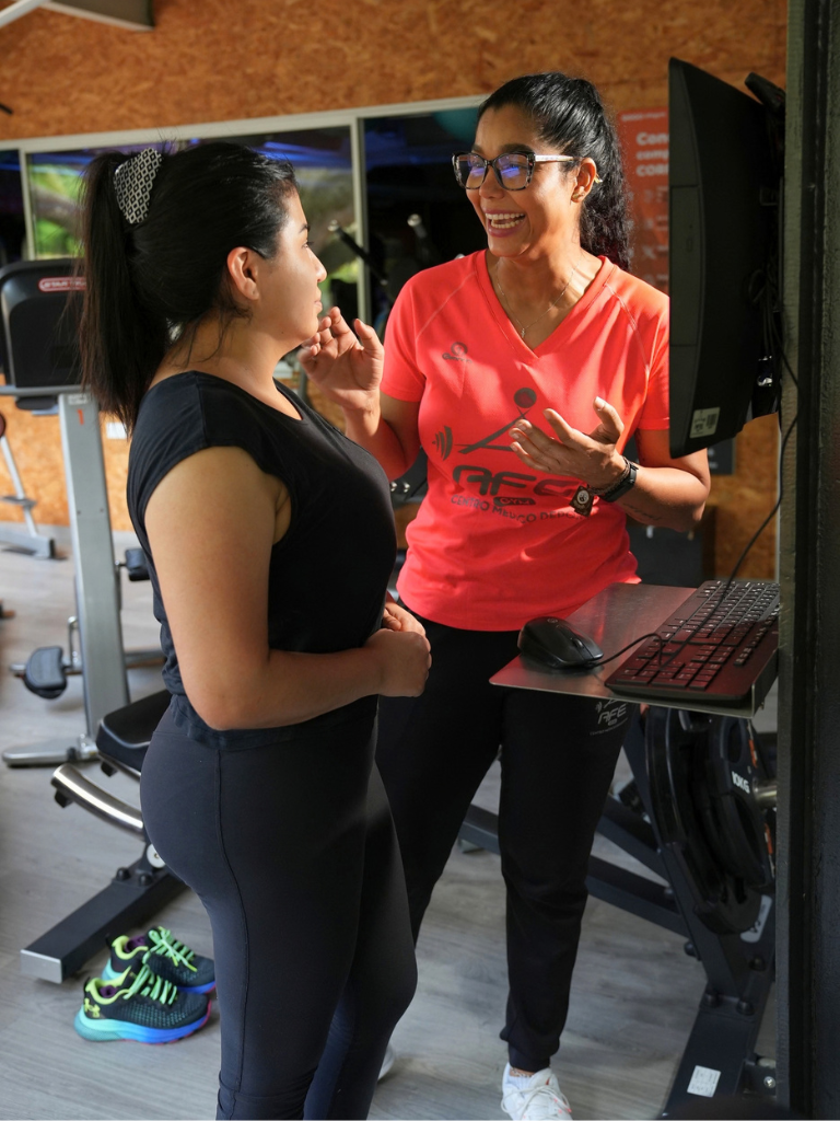 AFE GYM Entrenador conversando persona adula objetivos entrenamiento